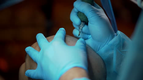 aplicando tatuaje de cabeza de cabello en un hombre audaz por especialista en belleza