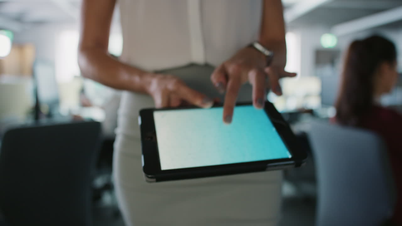 Business woman using digital tablet walking through busy office touchscreen display manipulating 3d shape