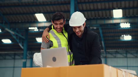 two factory worker celebrate success together in the factory