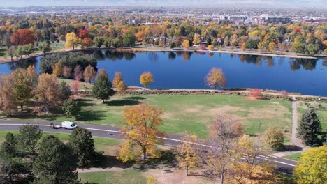 a 4k drone shot over washington park and tennis courts, mount vernon garden, and grasmere lake, in denver, colorado, on a peaceful day, during the colorful fall season