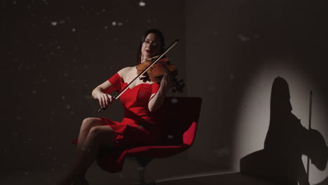 woman playing violin in red dress