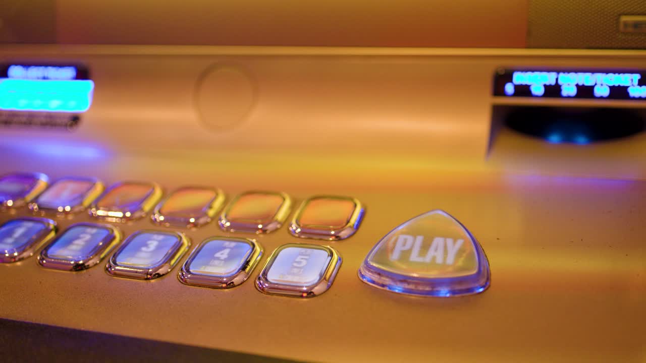 Close-up of illuminated slot machine buttons, hand pressing play, warm ambient casino lighting, steady shot