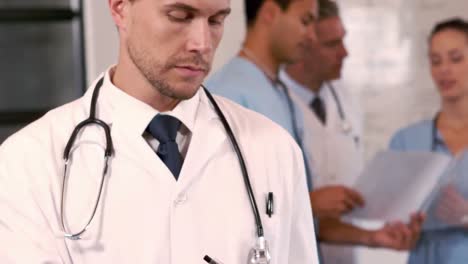 portrait of a doctor writing in his clipboard