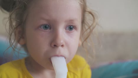 unhappy girl uses modern inhaler in light room closeup