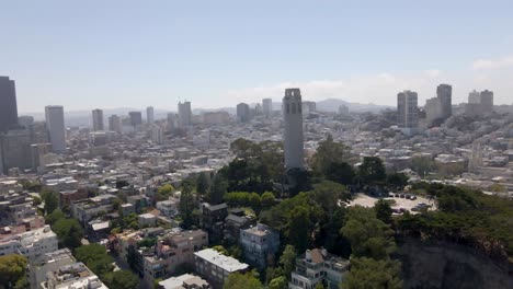 a mesmerizing drone circles around coit tower in san francisco, with the downtown skyscrapers forming a striking backdrop