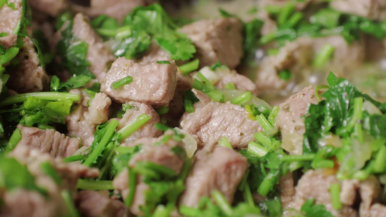 Chicken or pork stew with red and green pepper onion, and spices cooking in a frying pan. Traditional mexican cuisine, tacos preparation, ragout.