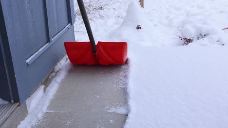 shoveling snow from sidewalk in front of house