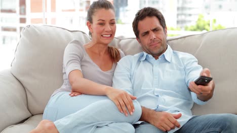relaxed couple watching tv on the couch