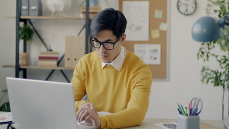 Young professional working on a laptop in a modern office