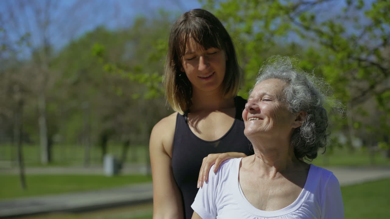 Mujer mayor concentrada haciendo ejercicio en un parque de verano con un entrenador