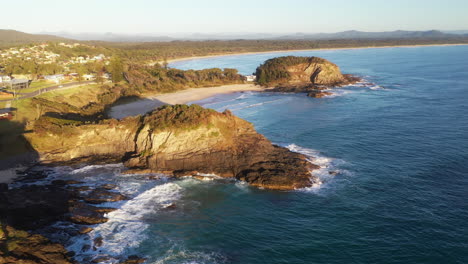 lowering drone shot of scotts head beach and rocky coastline in australia