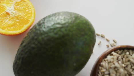video de primer plano de aguacate fresco, naranja y semillas sobre fondo blanco