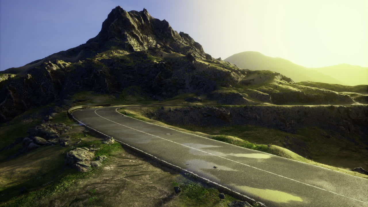Scenic winding road leading to a mountain during golden hour