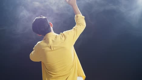 vista trasera de un niño con un micrófono y rap en el fondo blanco de humo negro