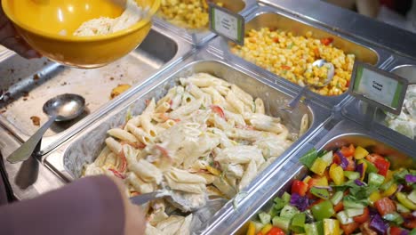 buffet de autoservicio con ensalada de pasta y verduras