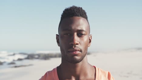 african american man looking and  smiling at camera seaside