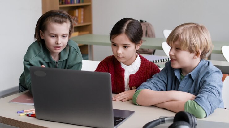 Kinder schauen auf Laptop im Klassenzimmer