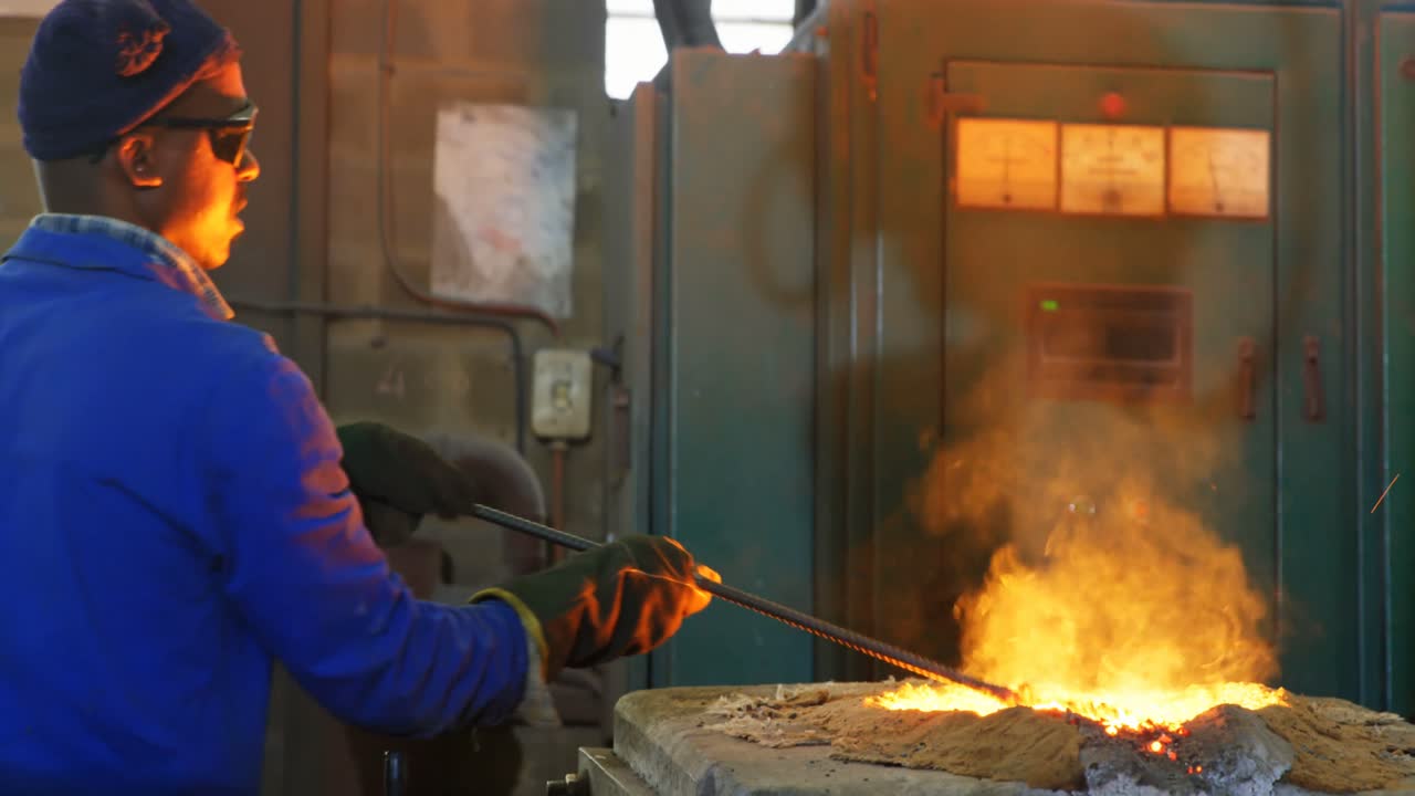 trabajador derritiendo metal en el horno en el taller 4k