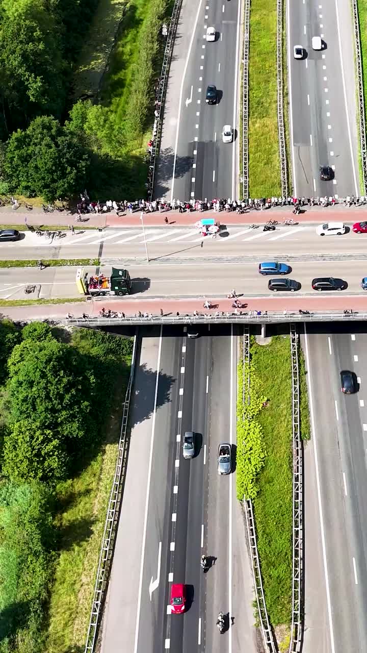 Aerial view of a highway with an overpass crowded with spectators