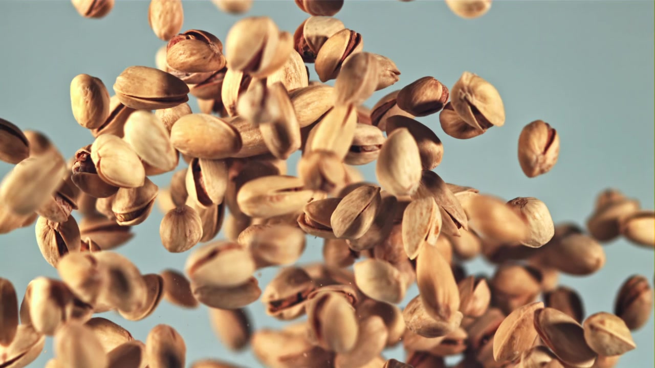 Pistachios Flying in Slow Motion Against a Light Blue Background
