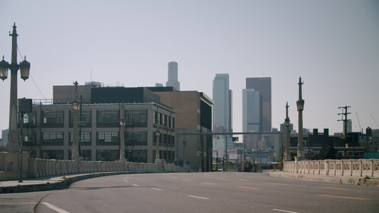 Urban cityscape view from a bridge with a prominent skyline and an empty road