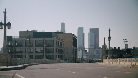 Urban cityscape view from a bridge with a prominent skyline and an empty road
