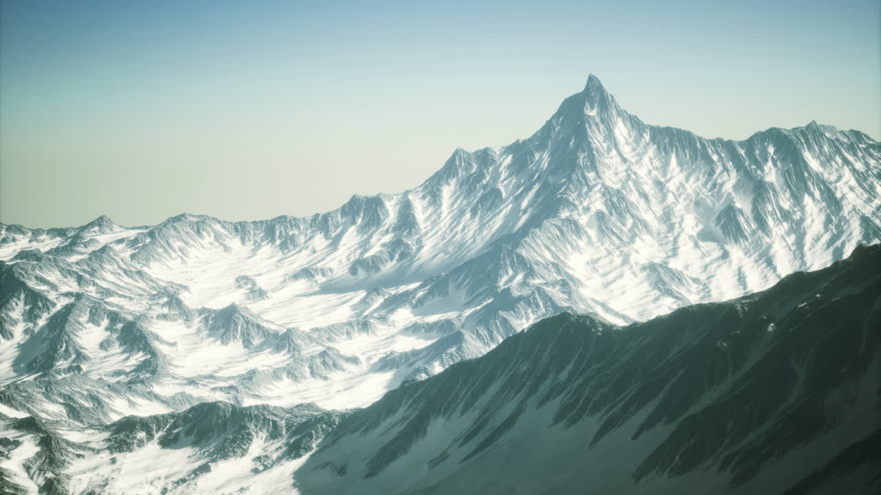 Majestic snow covered mountain peaks reaching for the clear sky at dawn