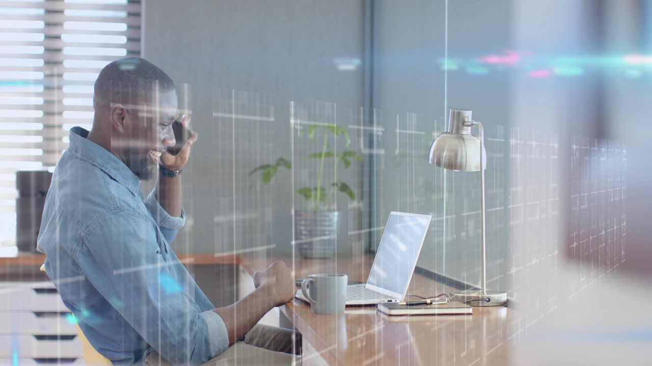Uomo alla scrivania che risponde al telefono, scrive e indica qualcosa sul portatile, sovrapposizione che evidenzia la finanza