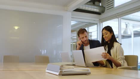 Business-colleagues-discussing-over-document-in-conference-room-4k