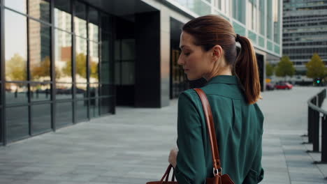 woman walking past a modern building in the city