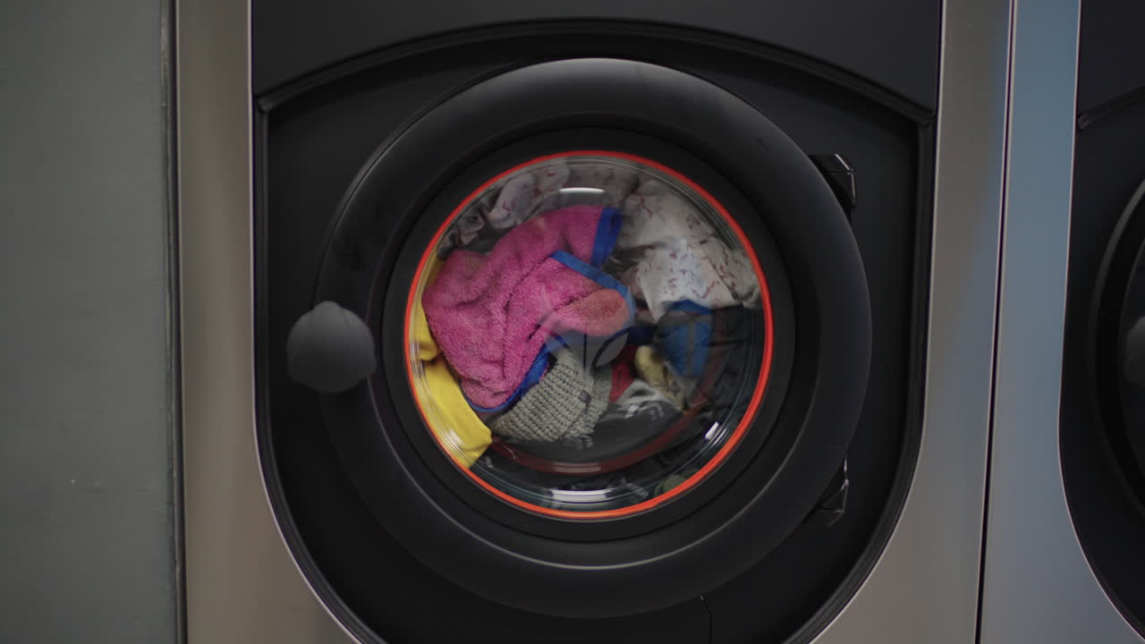 Laundry spins in a whirl, water splashing, fabrics twirling—a dance of cleanliness in motion