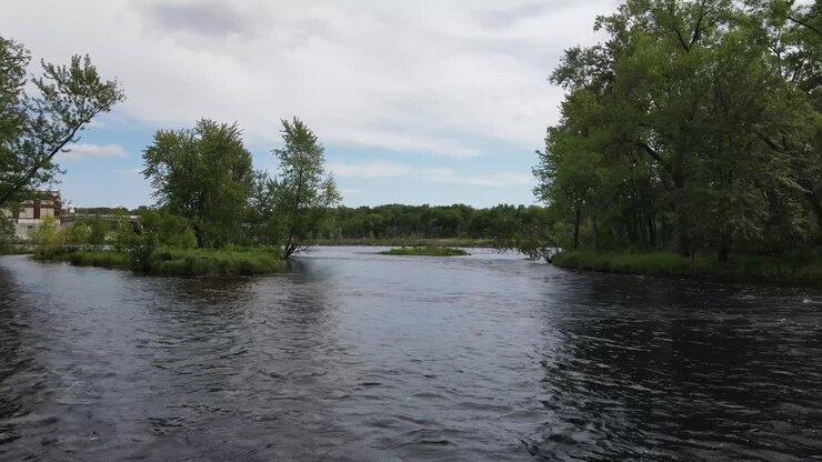 Flying above the river towards Chippewa Falls dam in Wisconsin. Closing up on a dam up the river.