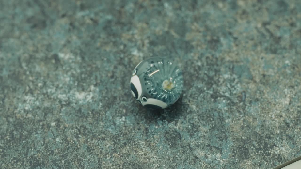 Close-up of a decorative glass marble on a textured surface