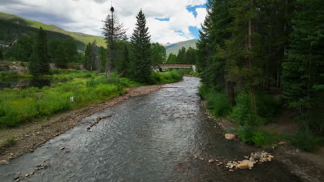 Keystone-River-Blue-fishing-golfing-peaceful-ski-resort-aerial-cinematic-drone-summer-Breckenridge-Colorado-Vail-resort-Epic-Pass-ski-snowboard-bike-biking-biker-bridge-path-slowly-forward-motion