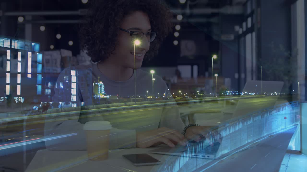 Animation of smiling woman using laptop in cafe, over sped up traffic in city at night