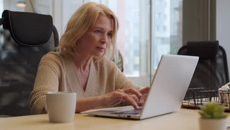 middle-aged woman typing on laptop