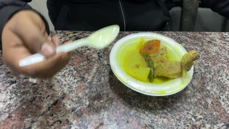 primer plano de la mano de un hombre indio mientras come el estofado de pollo al estilo bengalí servido en el hotel en dacres lane en kolkata
