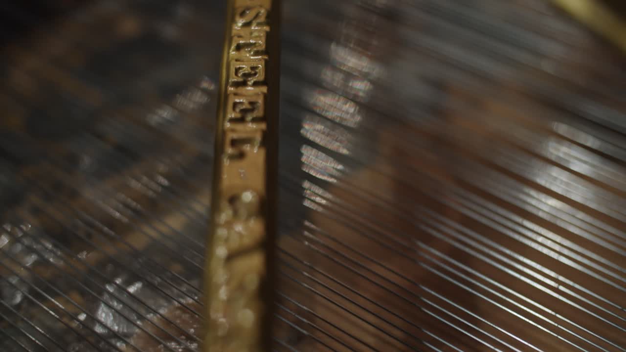 Close-up shot of the interior of a Steinway and sons piano- Piano strings - Black grand piano with open top - Professional studio - 4K at 60fps (slowmotion) - Professional audio vibes