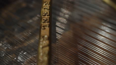 close-up shot of the interior of a steinway and sons piano- piano strings - black grand piano with open top - professional studio - 4k at 60fps (slowmotion) - professional audio vibes