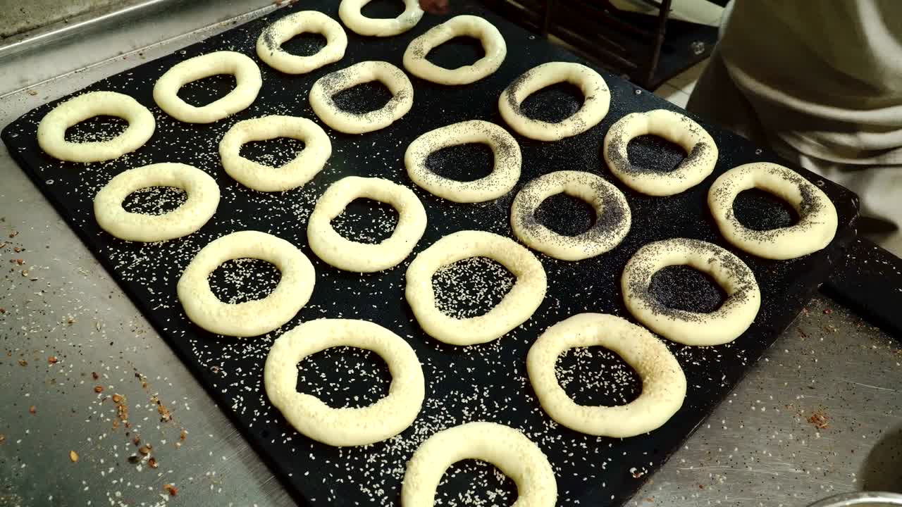 el panadero salpica bagels con semillas de sésamo y amapola