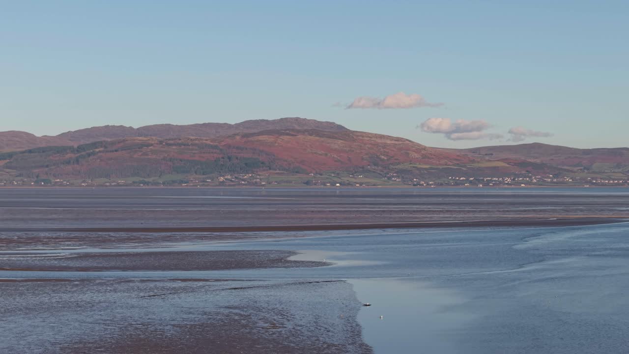 una escena costera tranquila de la aldea de blackrock, irlanda, con colinas y serenidad de la marea baja