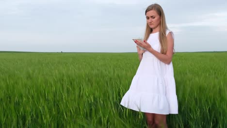 young girl uses a tablet a woman in a white dress in an open field young girl uses a tablet a woman in a white dress in an open field use of internet technologies
