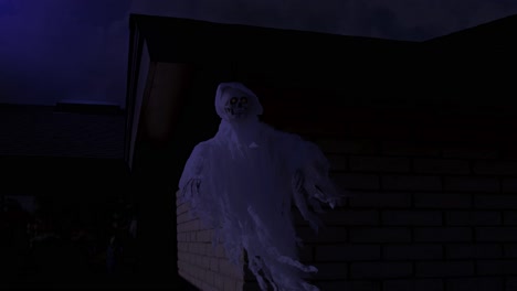 halloween skeleton ghost with red glowing eyed blows in the night wind