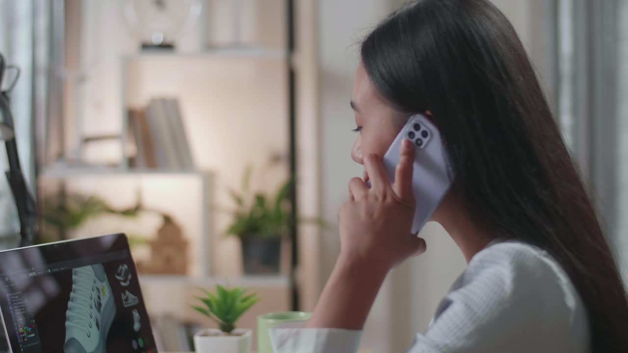 노트북에서 신발을 디자인하는 동안 전화로 이야기하는 여자