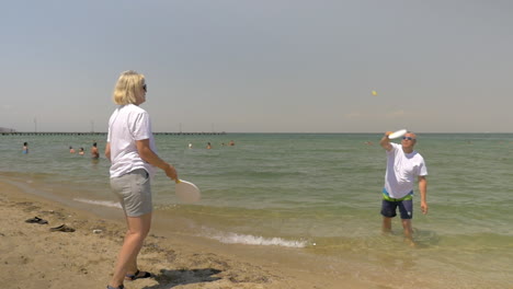 people playing beach tennis by the seaside