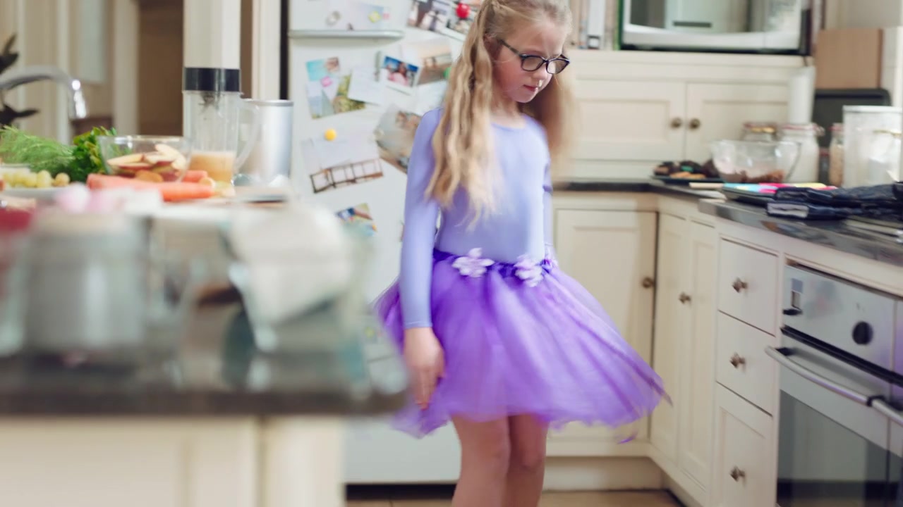Bambina che Balla in Cucina con un Tutù Viola