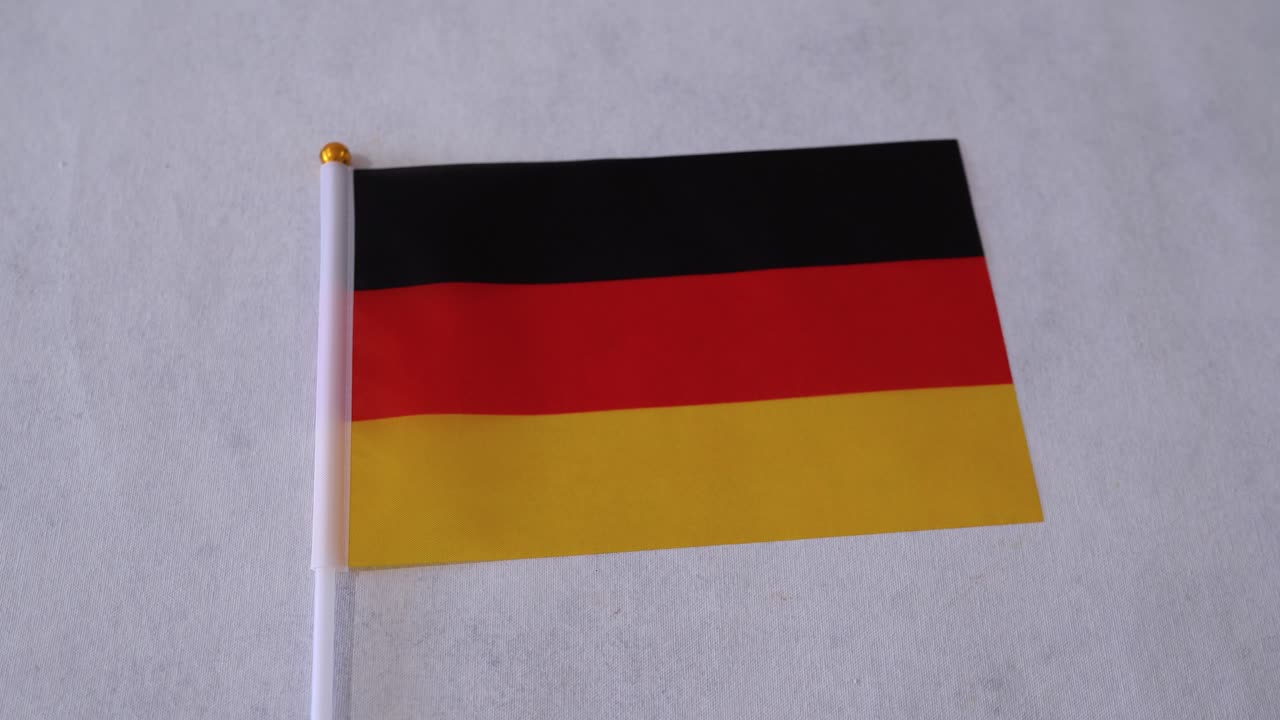 Primo piano della bandiera della Germania su sfondo bianco. Bandiera nazionale tedesca.