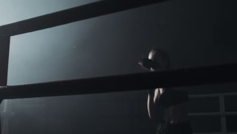woman boxing training in a dark ring