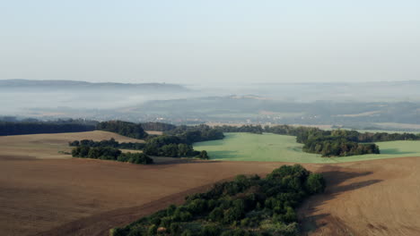 Mist-lying-over-an-idyllic-rural-countryside-in-Czechia,fields,hills