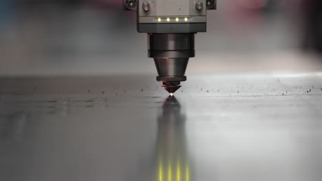 laser cutter cutting metal sheet with sparks - modern industrial equipment for metalwork